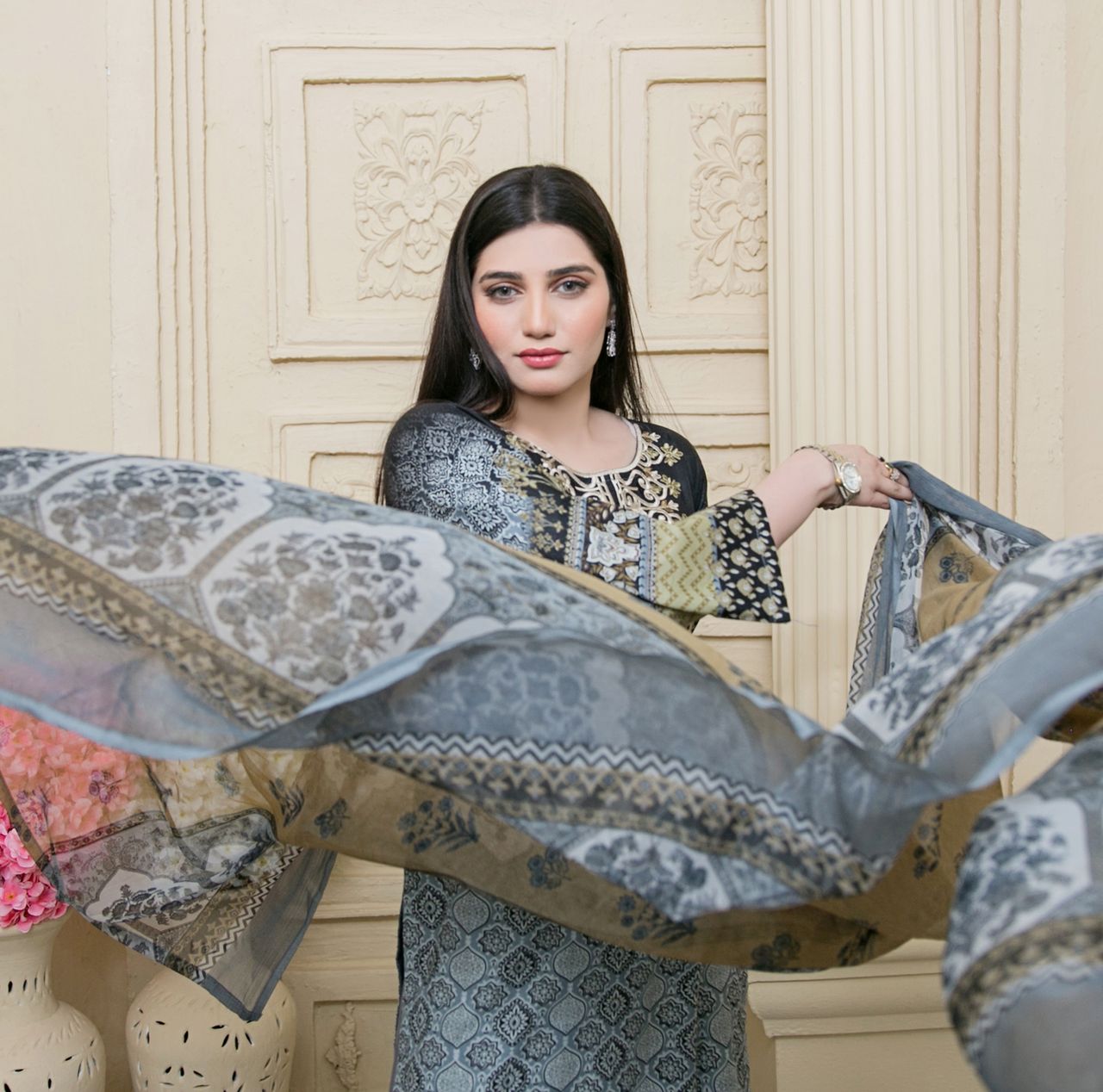 Portrait of a stylish woman in a beautiful traditional saree indoors.